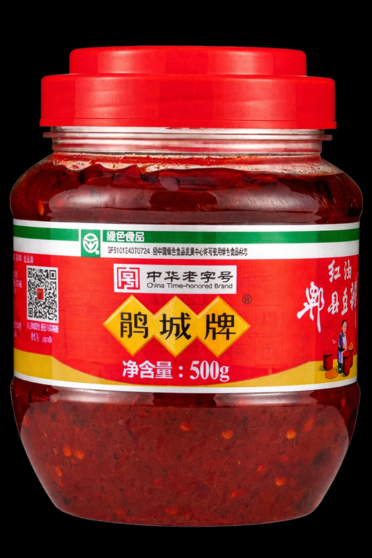 A jar of Juan Cheng Pixian Doubanjiang Broad Bean Sauce with Chili Oil on a dark background. 