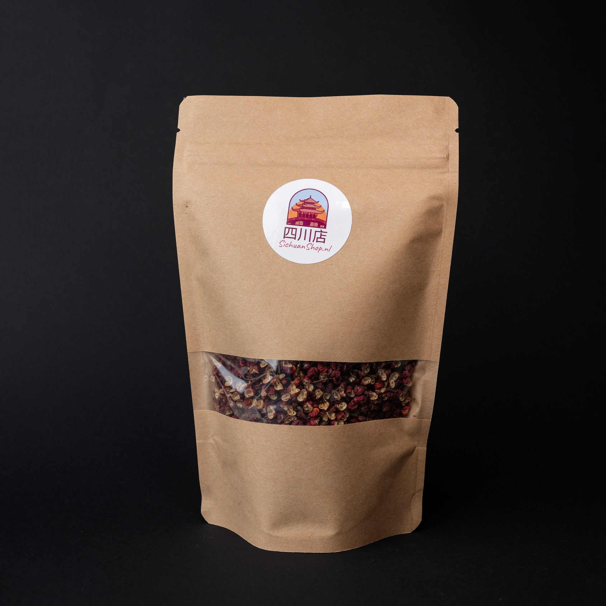 A package of red Sichuan peppercorns on a dark background. 