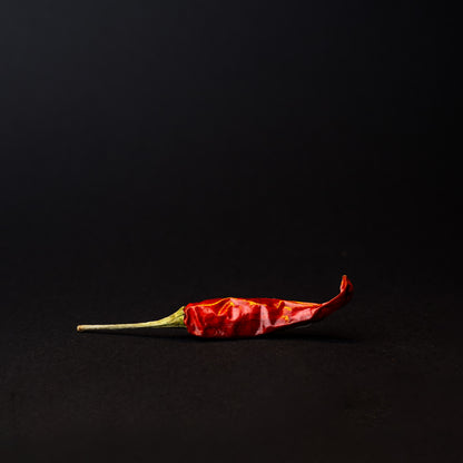 A xiao mi la chili pepper on a black background.