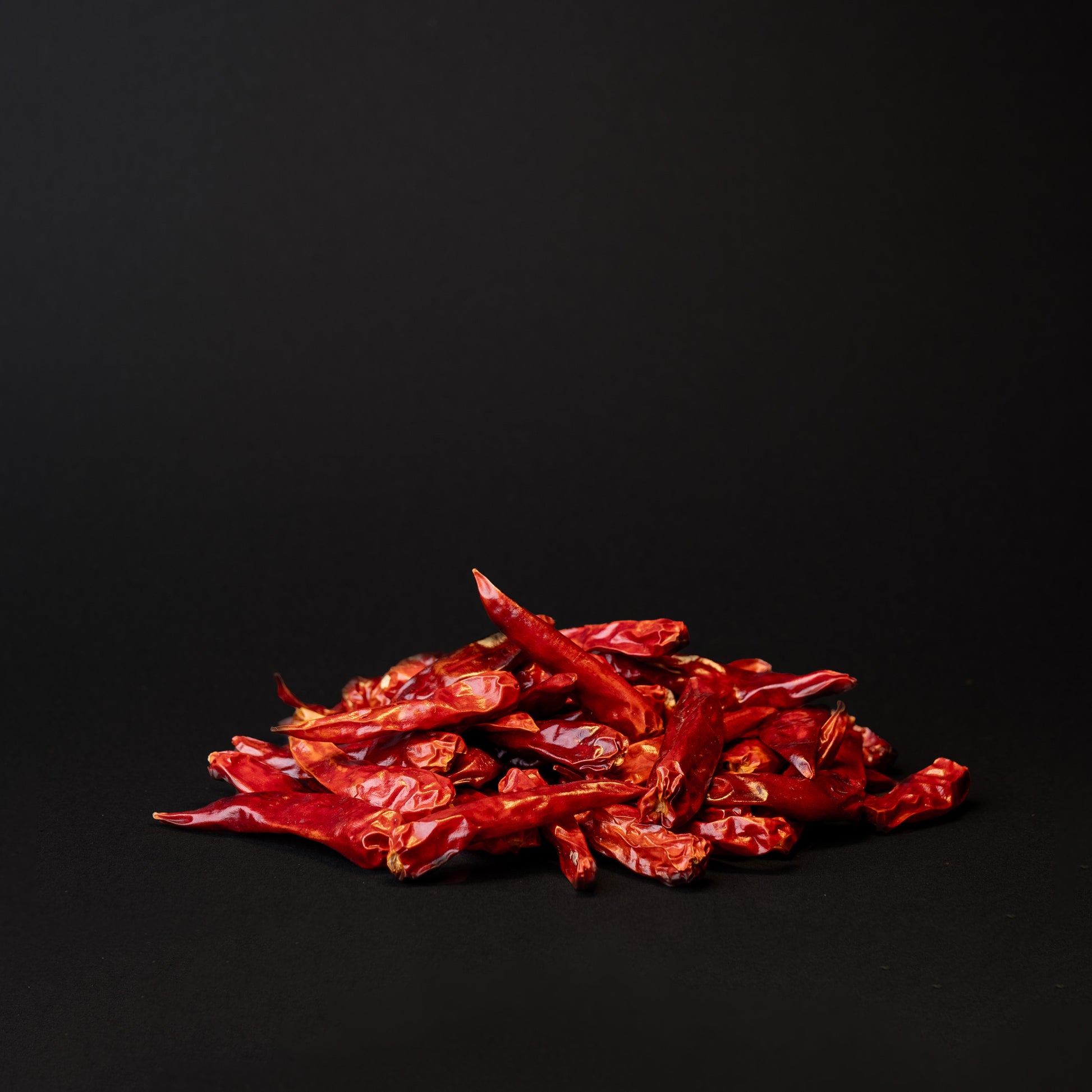 A pile of xiao mi la peppers on a black background. 