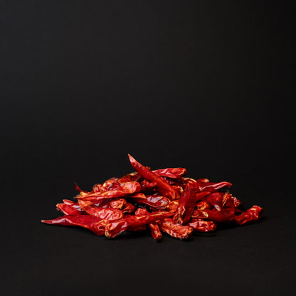 A pile of xiao mi la peppers on a black background. 